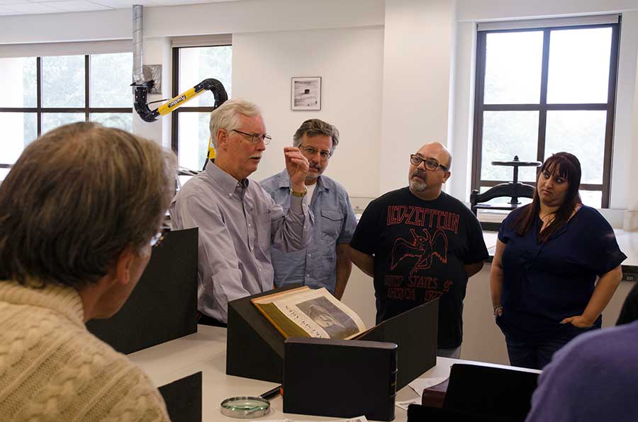Stephen Tabor (far left), curator of early printed books at The Huntington, shows a Third Folio, 1663, of Shakespeare’s collected plays to teachers attending the Shakespeare at The Huntington institute program in July 2015. The annual program brings theater professionals together with teachers, who learn innovative techniques for teaching Shakespeare through performance. Photograph by Lisa Blackburn. Stephen Tabor (far left), curator of early printed books at The Huntington, shows a Third Folio, 1663, of Shakespeare’s collected plays to teachers attending the Shakespeare at The Huntington institute program in July 2015. The annual program brings theater professionals together with teachers, who learn innovative techniques for teaching Shakespeare through performance. Photograph by Lisa Blackburn.